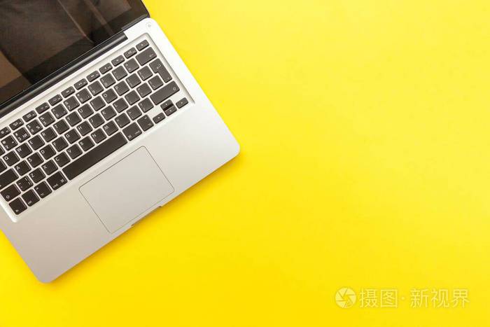 键盘笔记本电脑隔离在黄色桌面背景上现代信息技术与软件进步